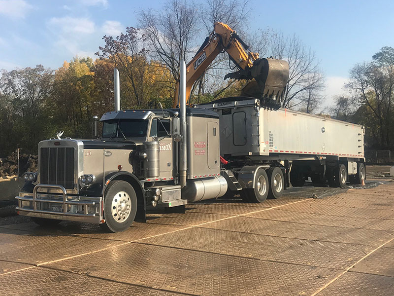 dry bulk end dump tractor trailer being loaded